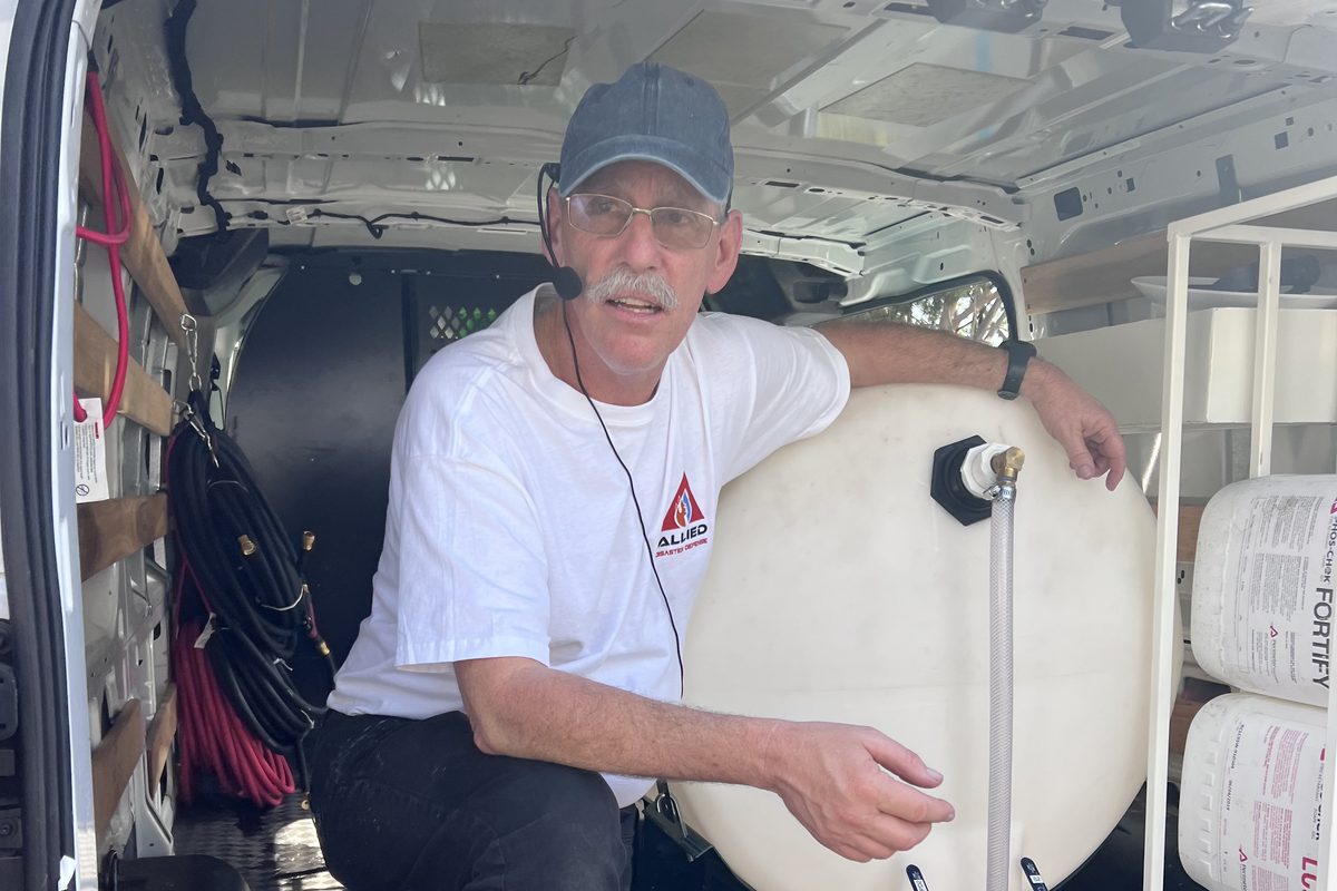 An Allied crew member with a tank, pump and retardant supply set up in a work van