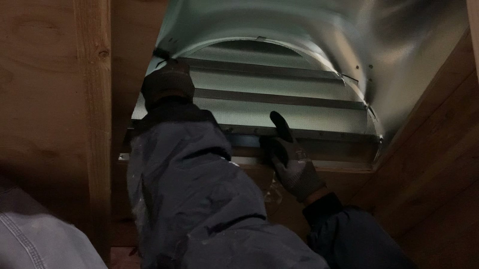 An Allied technician replacing an attic vent from inside the attic
